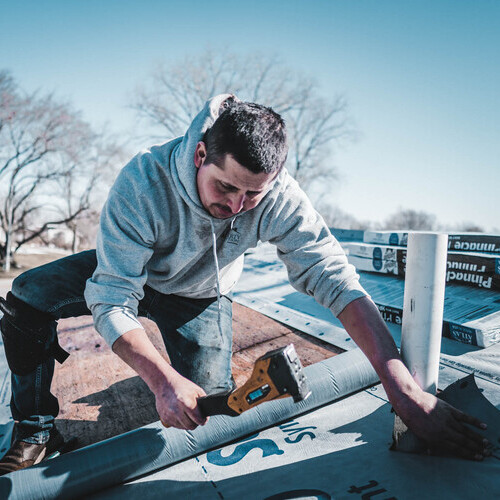 Roofer Works on a Residential Roof.